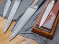 Selective focus on the blade of a steel kitchen knife lying on a water whetstone Royalty Free Stock Photo