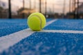 blue paddletennis court and one ball on the line at sundown, selective focus