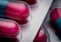 Selective focus of blue, pink capsule with granule in side pills. Pills in blister pack on white background. Pharmaceutical dosage Royalty Free Stock Photo