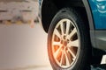 Selective focus on blue SUV car rear wheel on blurred background. Car with new high performance tire parked at garage workshop Royalty Free Stock Photo