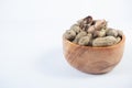 selective focus on boiled peanuts on wooden bowl isolated on white background