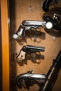 Selective focus, bokeh. background with old weapons. Pistol gun of old modification, close up, details of a firearm Royalty Free Stock Photo