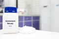 Selective focus of a bottle of Ammonium Nitrate in a plastic bottle beside a petri dish with white pellets. Royalty Free Stock Photo