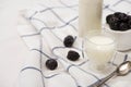 Selective focus of bottle and glass of yogurt near teaspoon and sugar bowl with blackberries on fabric Royalty Free Stock Photo