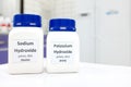 Selective focus of a bottle of pure sodium hydroxide and potassium hydroxide chemical compound. Chemistry research laboratory. Royalty Free Stock Photo