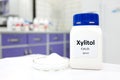 Selective focus of a bottle of pure xylitol sugar substitute with powder in petri dish. White laboratory background Royalty Free Stock Photo