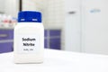 Selective focus of a bottle of sodium nitrite preservative chemical compound.