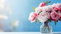 Selective focus on a bouquet of fresh tender white, pink, purple and red peonies in a glass vase against a pastel white and blue