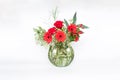 Selective focus bouquet of mix red flower in transparent green vase on white background isolated Royalty Free Stock Photo