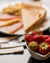 Selective focus of a bowl of fresh strawberries with a breakfast plate in the background Royalty Free Stock Photo