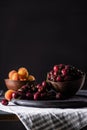 selective focus of bowls with ripe cherries and apricots on wooden table Royalty Free Stock Photo