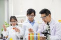 Selective focus at boy face. Young Asian boy and girl study science class using Microscope and chemical liquid to do the Royalty Free Stock Photo