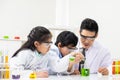 Selective focus at boy face. Young Asian boy and girl study science class using Microscope and chemical liquid to do the Royalty Free Stock Photo