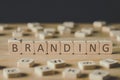 Focus of branding lettering on cubes surrounded by blocks with letters on wooden surface isolated on black