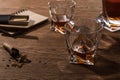 Selective focus of brandy in glasses with cigars, lighter and matches on wooden table