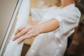 Selective focus of a bride's hand with a promise ring holding her white wedding dress