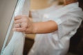 Selective focus of a bride& x27;s hand with a promise ring holding her white wedding dress