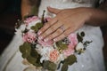 Selective focus of a bride's hands with a promise ring on the background of a bridal bouquet