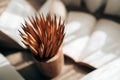 Selective focus of a bunch of pencils in a holder next to open books on a table