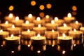 Selective focus of burning candles glowing in darkness with bokeh lights