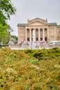 Selective focus of a bush at the park on a blurred background of the Grand Theater, Poznan, Poland Royalty Free Stock Photo
