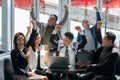 Selective focus of a Businessman raising arms to celebrate business success with his colleague in the coffee lounge