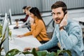 Selective focus of call center operator looking at camera while multiethnic colleagues working Royalty Free Stock Photo