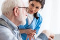 Focus of calm nurse talking to elderly patient