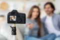 Selective focus on camera filming couple of bloggers Royalty Free Stock Photo