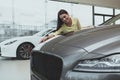 Elegant young woman buying new car at dealership Royalty Free Stock Photo