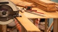 Carpenter is cutting plank by electronic saw. Blurred background is tool and ply wood on the table. Royalty Free Stock Photo