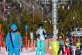 Selective focus on Caucasian white woman, skier riding up on draglift