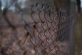 Selective focus of chain fence in a field against a blurred background Royalty Free Stock Photo