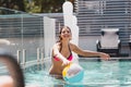 Focus of cheerful girl in swimwear reaching beach ball in swimming pool Royalty Free Stock Photo