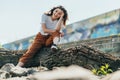 Focus of cheerful woman sitting on tree trunk