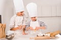 selective focus of in chef hats and aprons whisking eggs in bowl at table Royalty Free Stock Photo