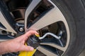 Selective focus on chemical additive sprayed from a can into a tire to fix a flat Royalty Free Stock Photo