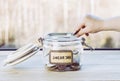 Selective focus on child hand  put euro coin in swear jar. Royalty Free Stock Photo