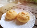 Selective focus of Choux cream in white plate on wooden table with sun shining in cafÃÂ©