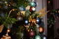 Selective focus. Christmas decorations in the form of balloons and ribbons on a pine tree against the background of lights of Royalty Free Stock Photo