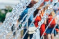 Spray fountain in the center of city with selective focus and blurred background. Running fountain with splashes and Royalty Free Stock Photo