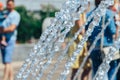 Selective focus on city fountain splashes and blurred background. The fountain works with splashes and drops of water Royalty Free Stock Photo