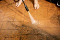 Selective focus. Cleaning backyard paving tiles with high pressure washer Royalty Free Stock Photo