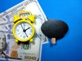 Selective focus.Clock,dollar banknote and copy space on wooden board with blue background.Shot were noise and film grain. Royalty Free Stock Photo