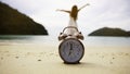 clock with woman playing yoga and stretching muscles on the beach sunlight in morning scene Royalty Free Stock Photo