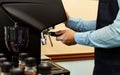 Selective focus and close up on barista`s hands preparing coffee for customers and using equipment, pressing machine for brewing