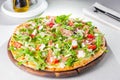 Selective focus Close up Delicious Pizza with hamon and cherry tomato slices, parmezan cheese and arugula on the wooden board Royalty Free Stock Photo