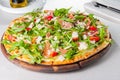 Selective focus Close up Delicious Pizza with hamon and cherry tomato slices, parmezan cheese and arugula on the wooden board on Royalty Free Stock Photo