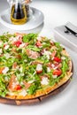 Selective focus Close up Delicious Pizza with hamon and cherry tomato slices, parmezan cheese and arugula on the wooden board on Royalty Free Stock Photo