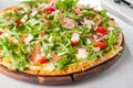 Selective focus Close up Delicious Pizza with hamon and cherry tomato slices, parmezan cheese and arugula on the wooden board on Royalty Free Stock Photo